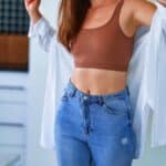 Sexual woman with beautiful thin fit body figure and slim waist wearing jeans, top and white shirt