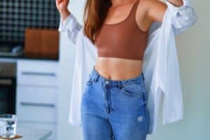 Sexual woman with beautiful thin fit body figure and slim waist wearing jeans, top and white shirt