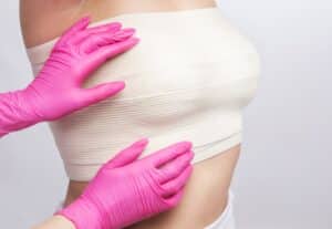 Close-up of a woman's chest with a bandage, representing recovery after silicone breast explant surgery and a breast lift following implant removal