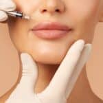 Young woman getting lip injections with dermal fillers