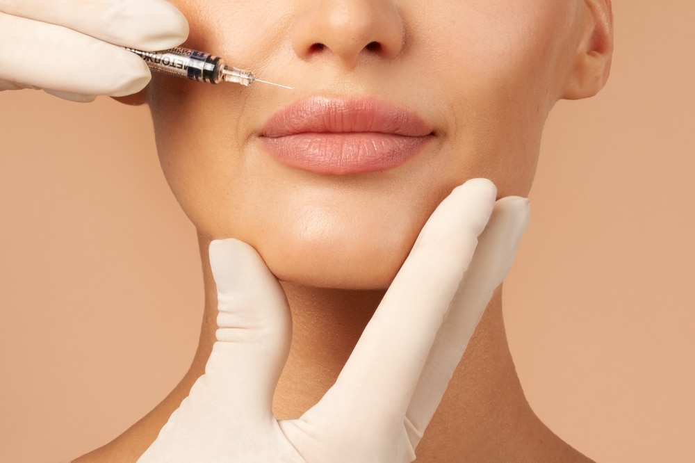 Young woman getting lip injections with dermal fillers