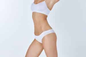 Woman with a slimmer waist and toned abdomen after weight loss and body contouring procedures.